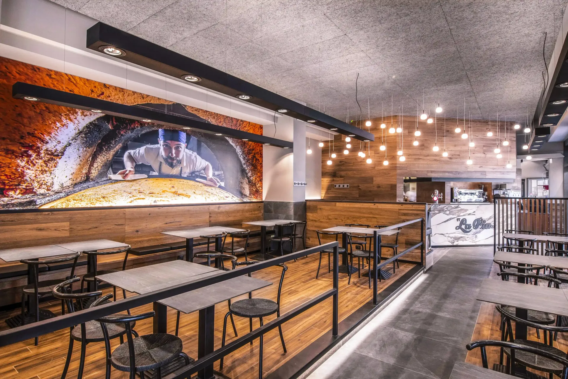 Un ristorante con tavoli e sedie e un dipinto sul muro