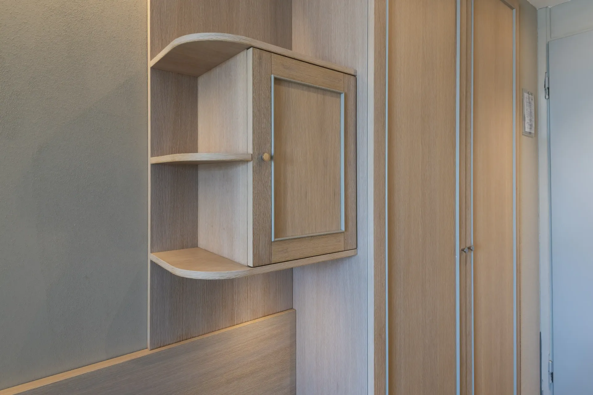 Un angolo di una stanza con uno scaffale e uno specchio