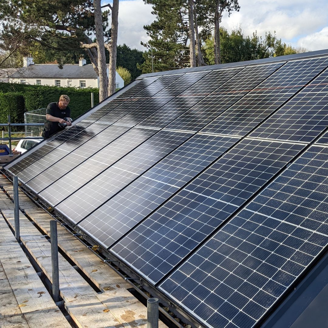 Johnathan Gower working on a roof with solar panels