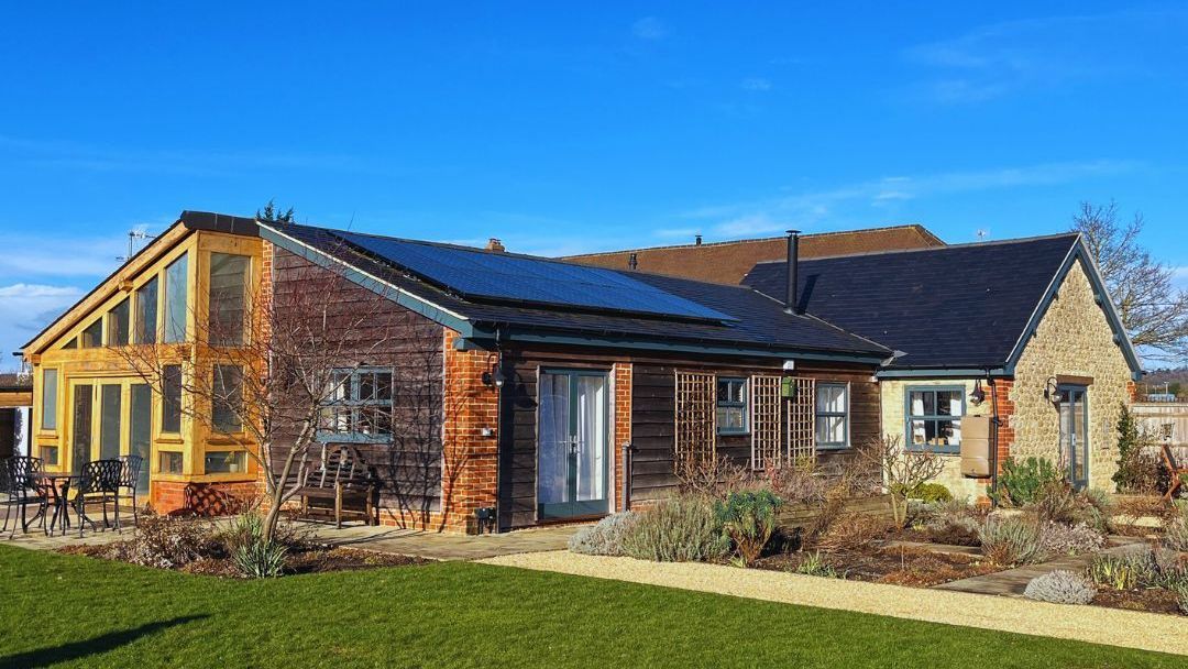 A large house with a lot of windows and solar panels on the roof.