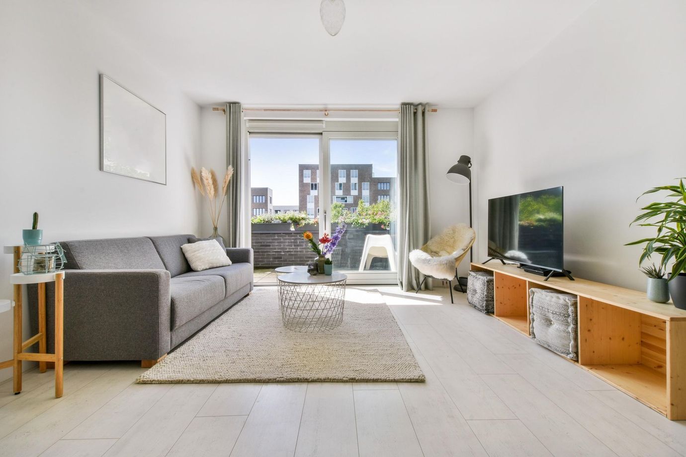 A living room with a couch, chair, table and television.