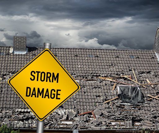 A yellow sign that says storm damage is in front of a damaged roof.