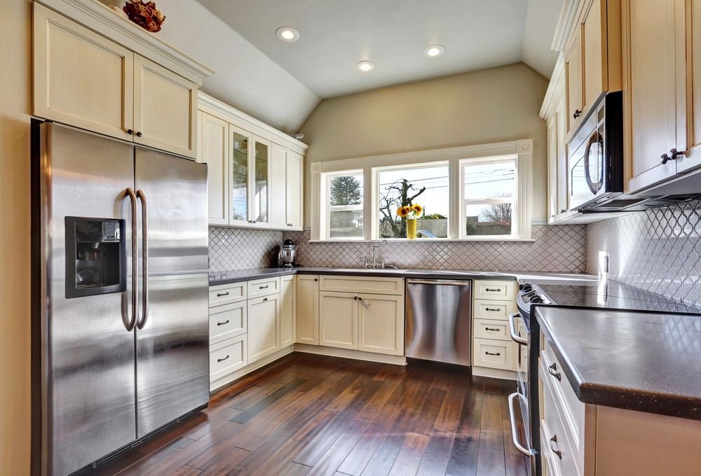 A Kitchen With Stainless Steel Appliances and White Cabinets — Gavin Cummings Kitchens in Dubbo, NSW