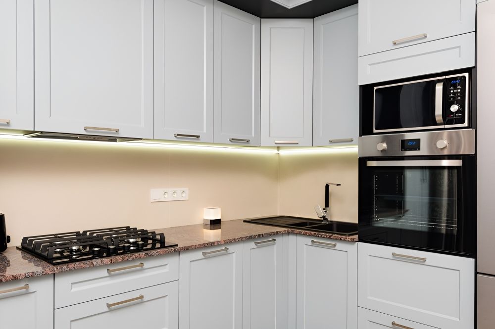 A Kitchen With White Cabinets And Stove Top Oven — Gavin Cummings Kitchens in Nyngan, NSW