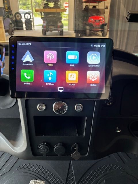 Car dashboard with a touchscreen infotainment display showing app icons and climate controls below