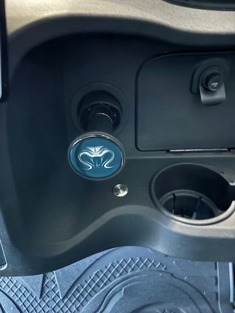Car dashboard with a blue rose-shaped accessory and open cup holder area