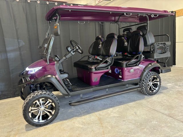 Purple golf cart with black seats and canopy parked indoors