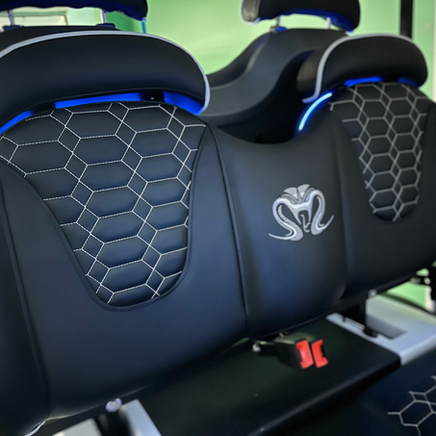 Black car rear seats with hex-pattern covers and blue accent lighting inside the cabin