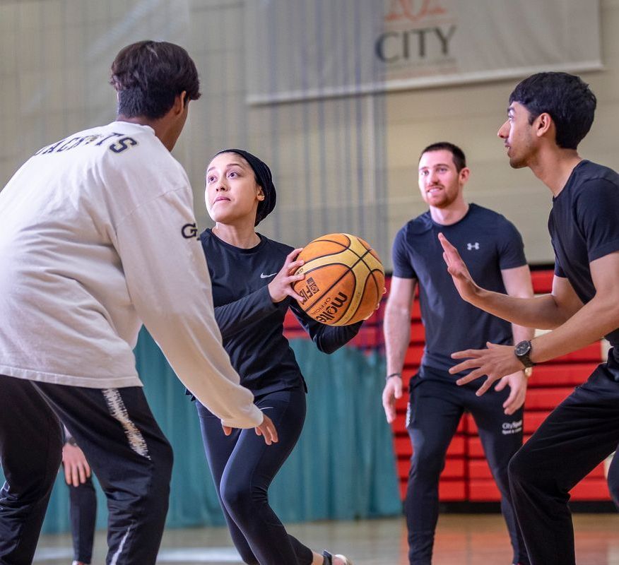 Four students play basketball