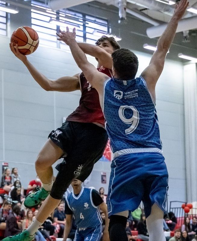 two students playing basketball from different teams