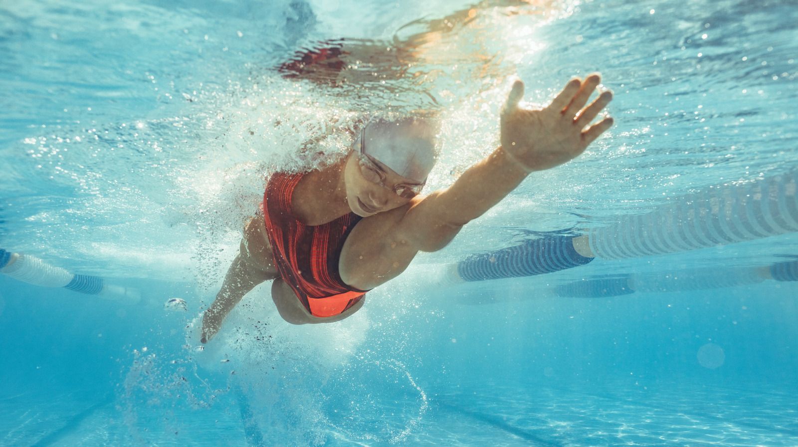 Swimmer in the pool, head down stretching forward in a front crawl