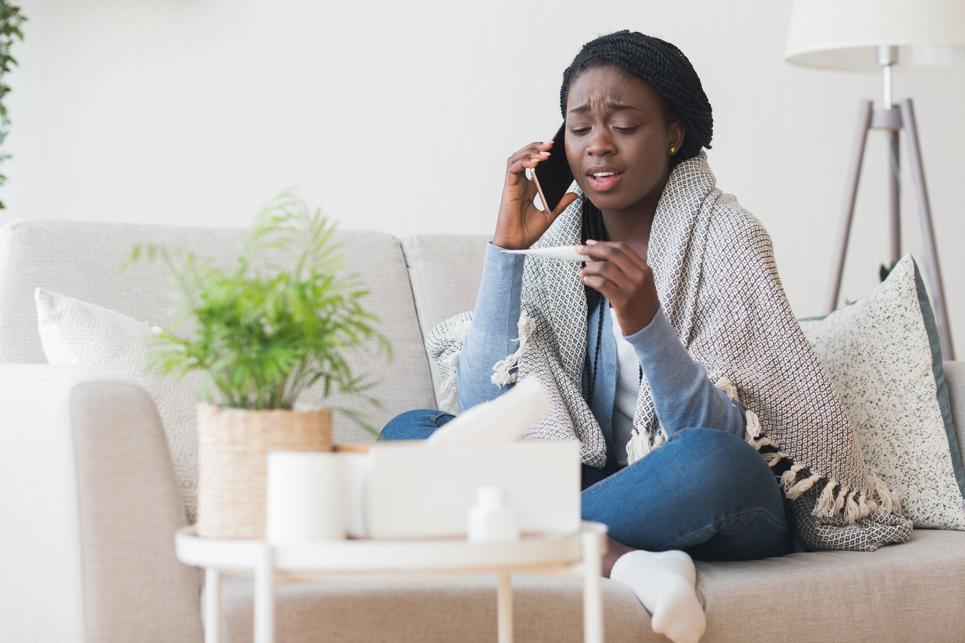 A woman is sitting on a couch talking on a cell phone.