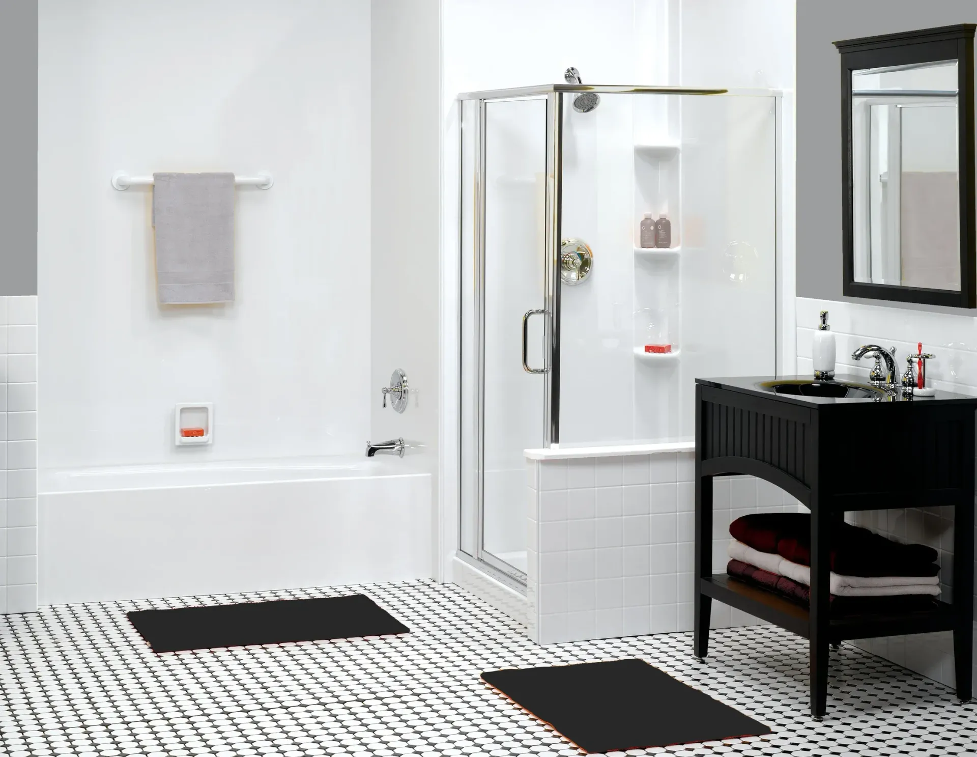 Modern bathroom with white tiled shower, black vanity, and patterned floor mats
