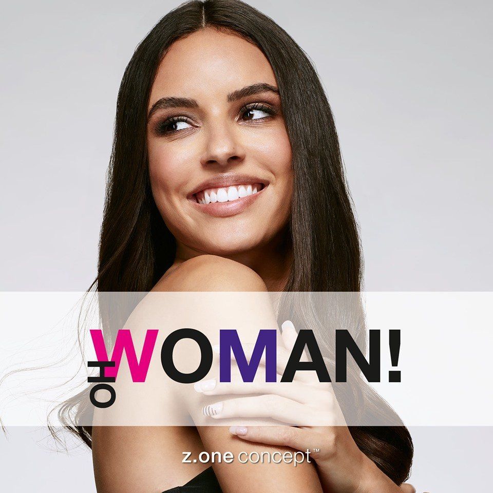 Una mujer sonríe delante de un cartel que dice mujer.