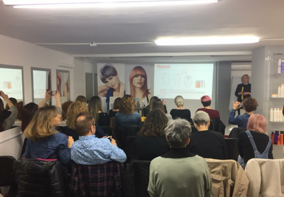 Un grupo de personas está sentado frente a una pantalla de proyector en una habitación.