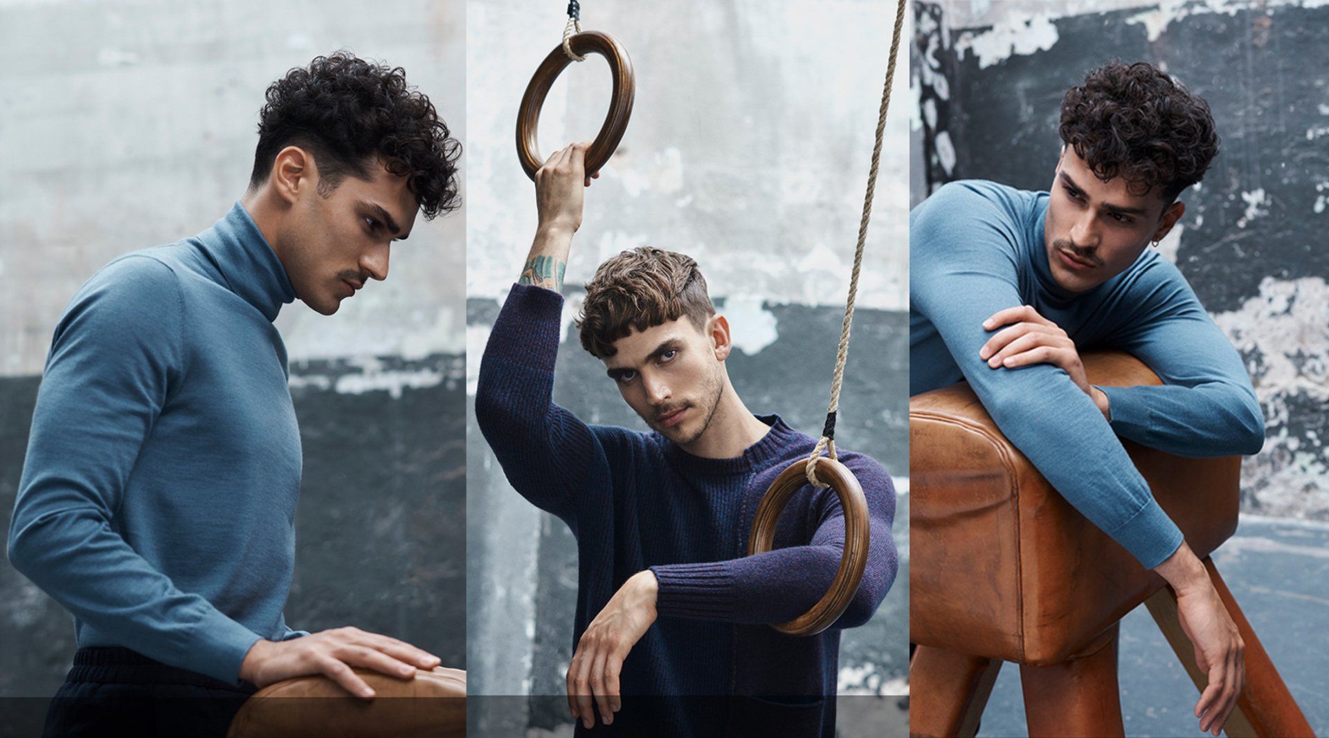 Un hombre con un suéter de cuello alto azul sostiene un anillo de gimnasia.