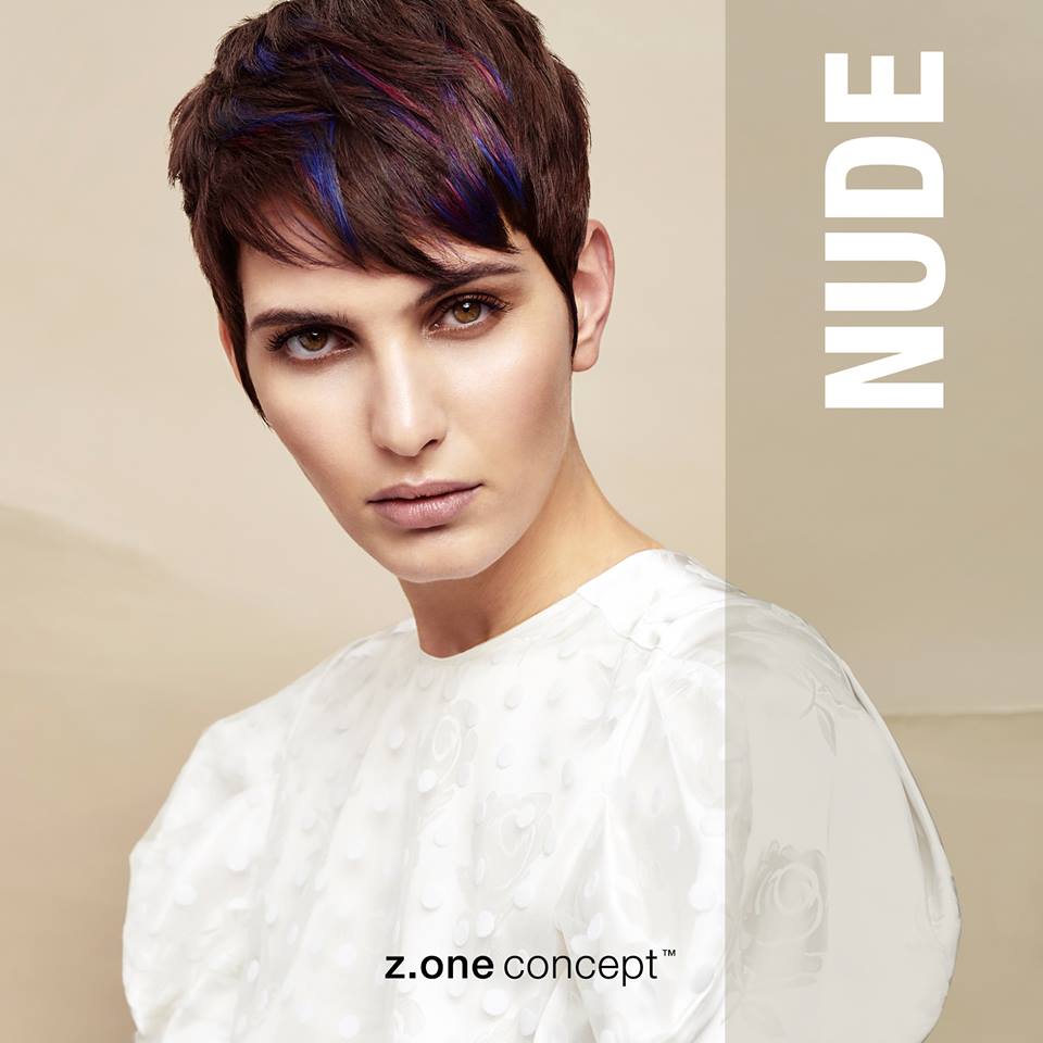 Una mujer con pelo corto lleva una camisa blanca.