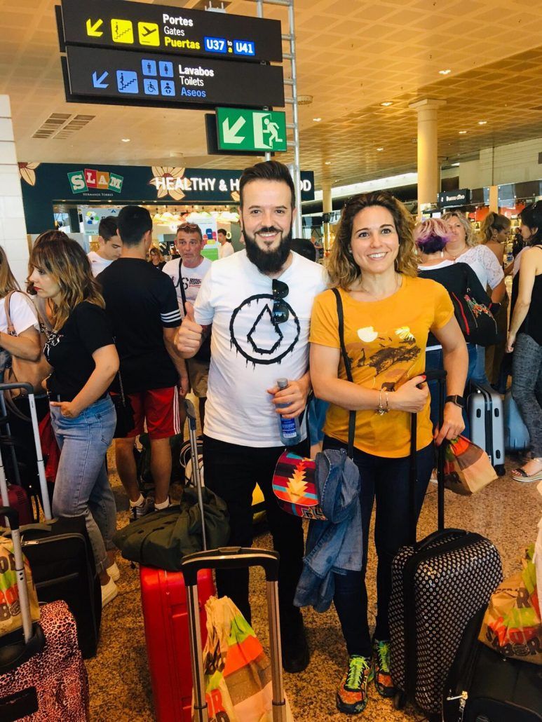 Un hombre y una mujer están parados en un aeropuerto con equipaje.