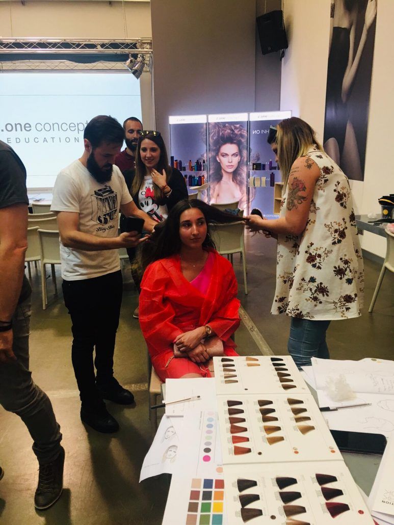 Un grupo de personas está de pie alrededor de una mujer sentada en una mesa.