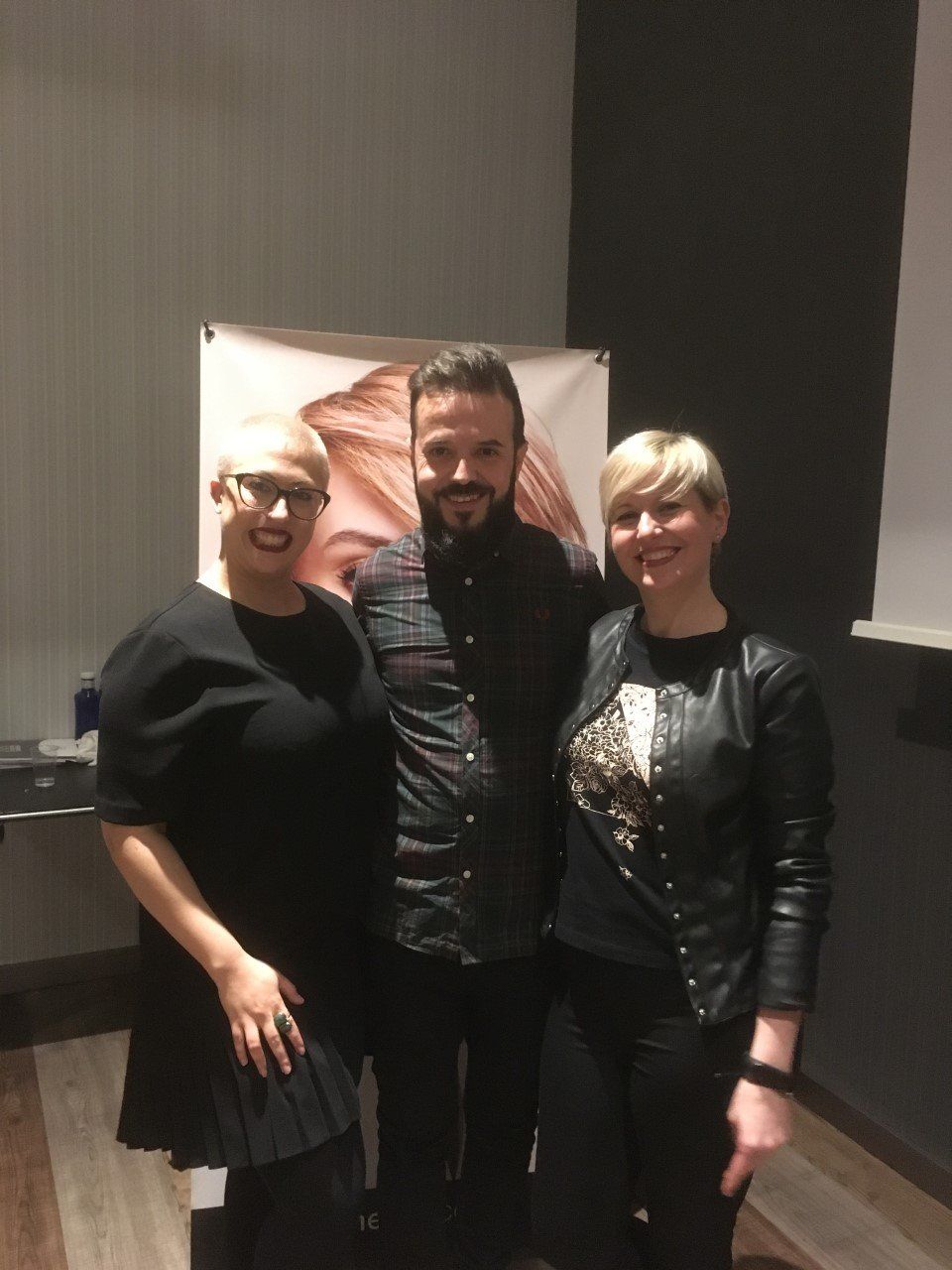 Un hombre y dos mujeres posan para una fotografía.