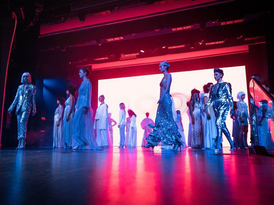Un grupo de modelos camina por una pasarela en un desfile de moda.