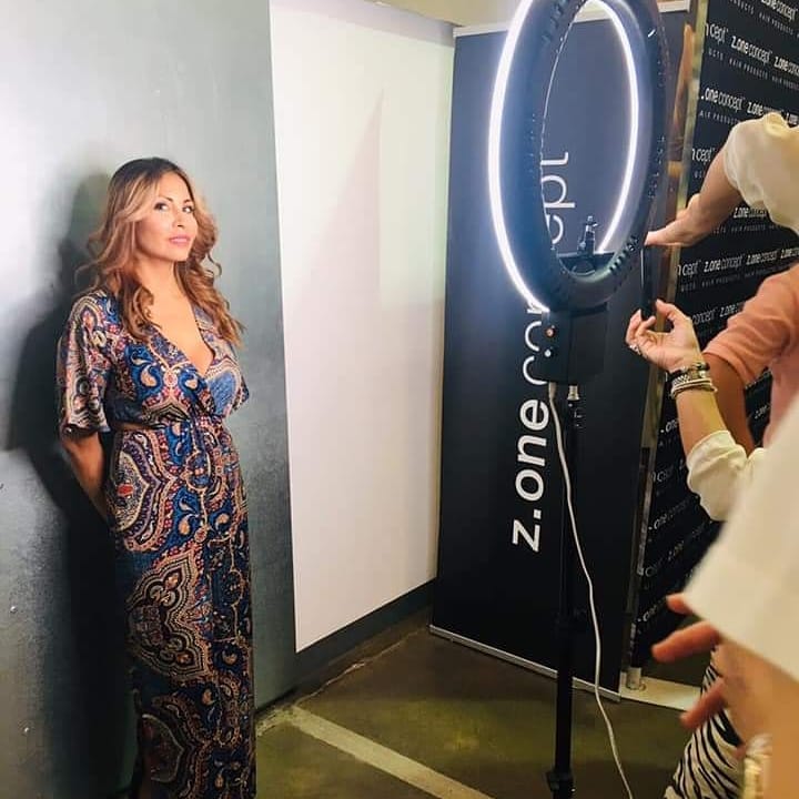 Una mujer está parada frente a un cartel de zona uno.