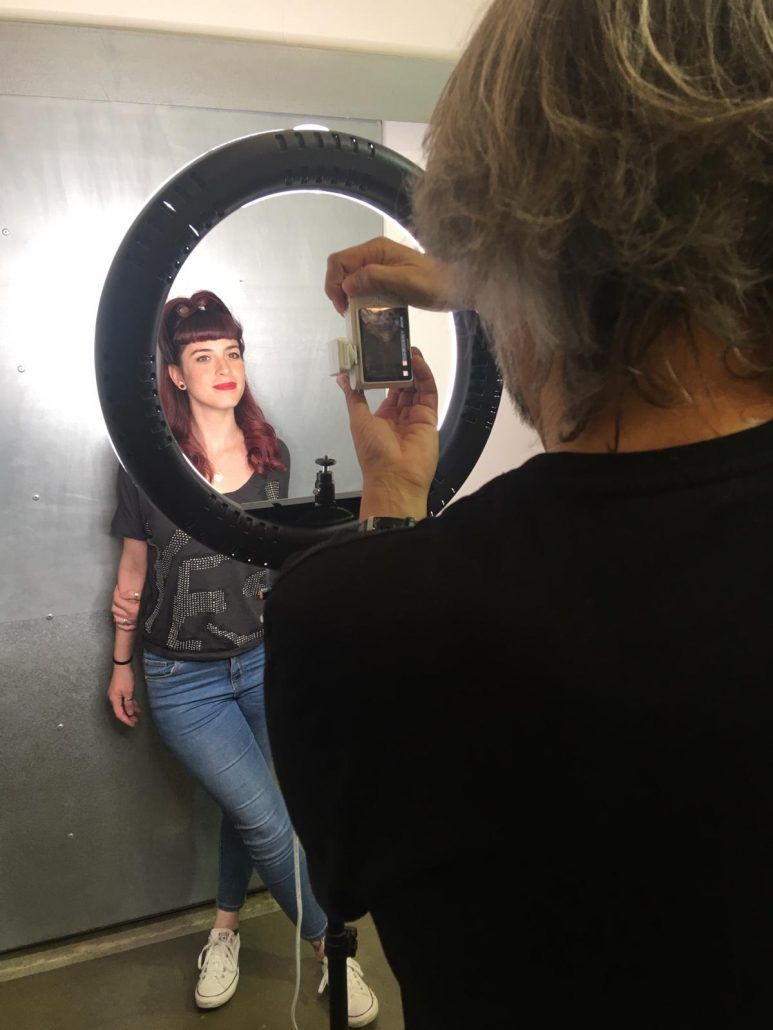 Un hombre está tomando una fotografía de una mujer frente a un espejo.