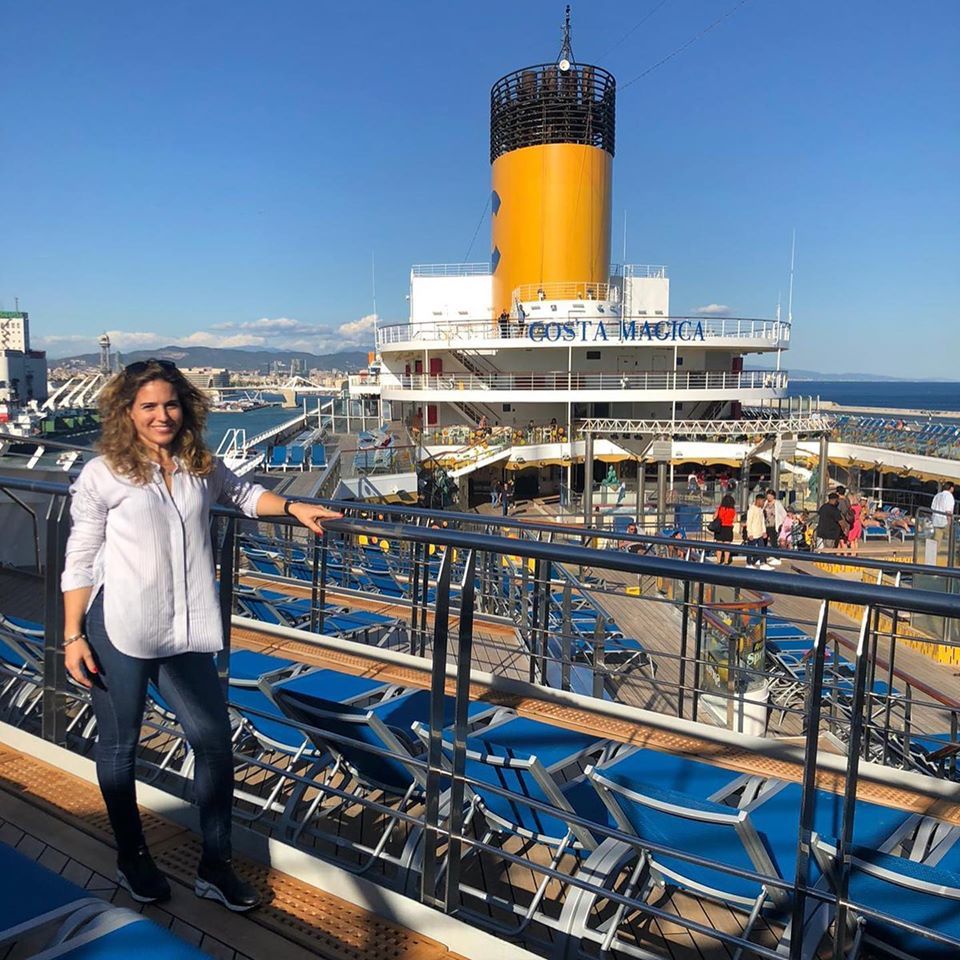Una mujer está de pie en la cubierta de un crucero.