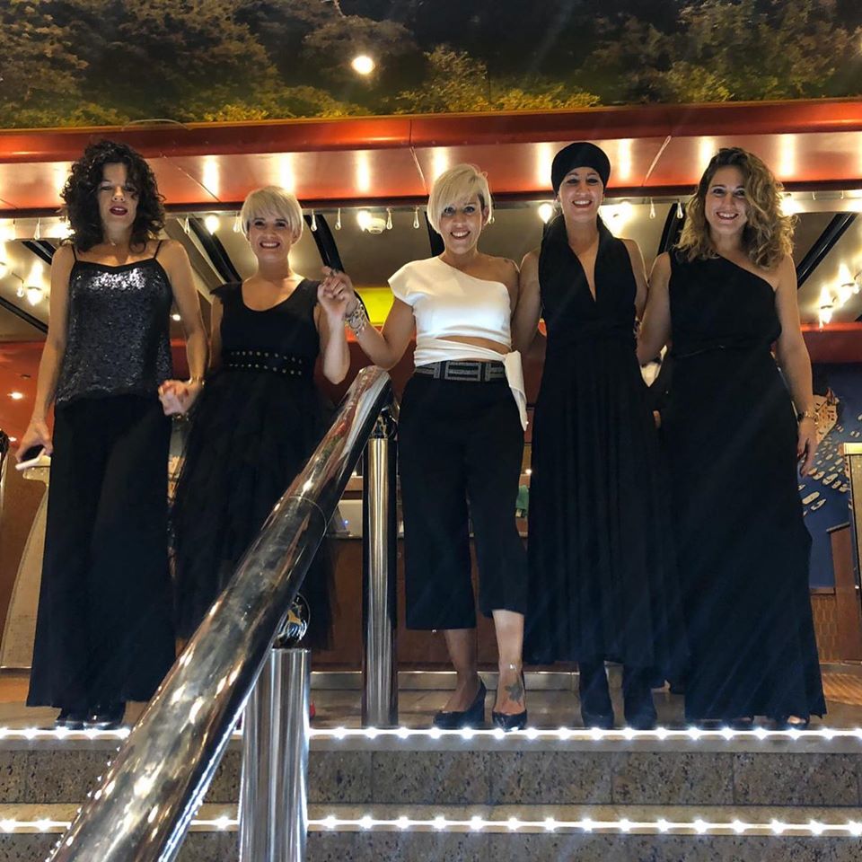 Un grupo de mujeres posa para una foto en unas escaleras.