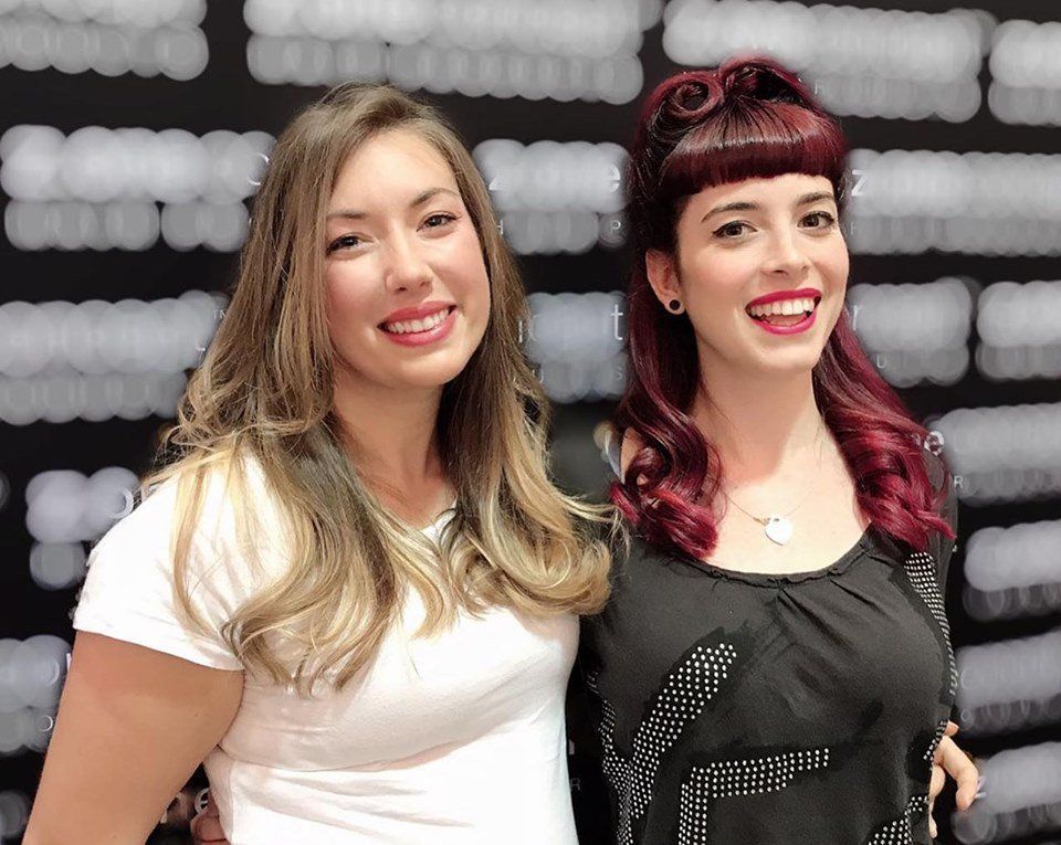 Dos mujeres posan para una foto y una tiene el pelo rojo.