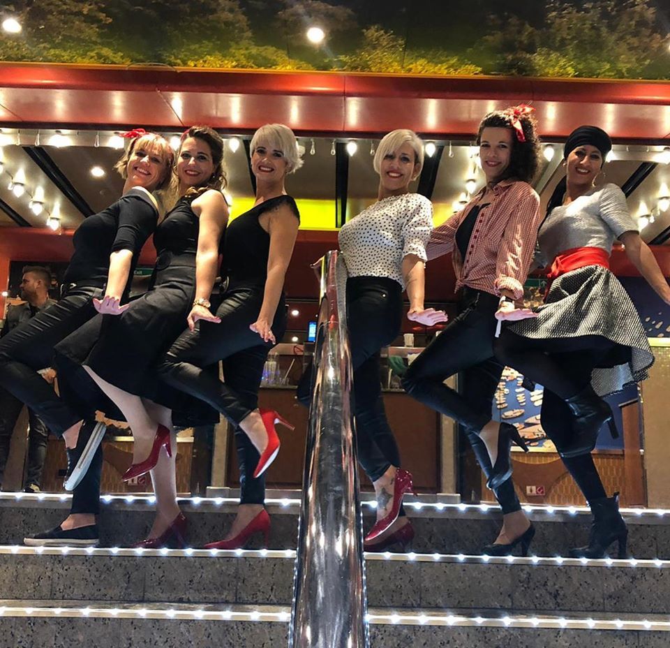 Un grupo de mujeres posa para una foto en unas escaleras.