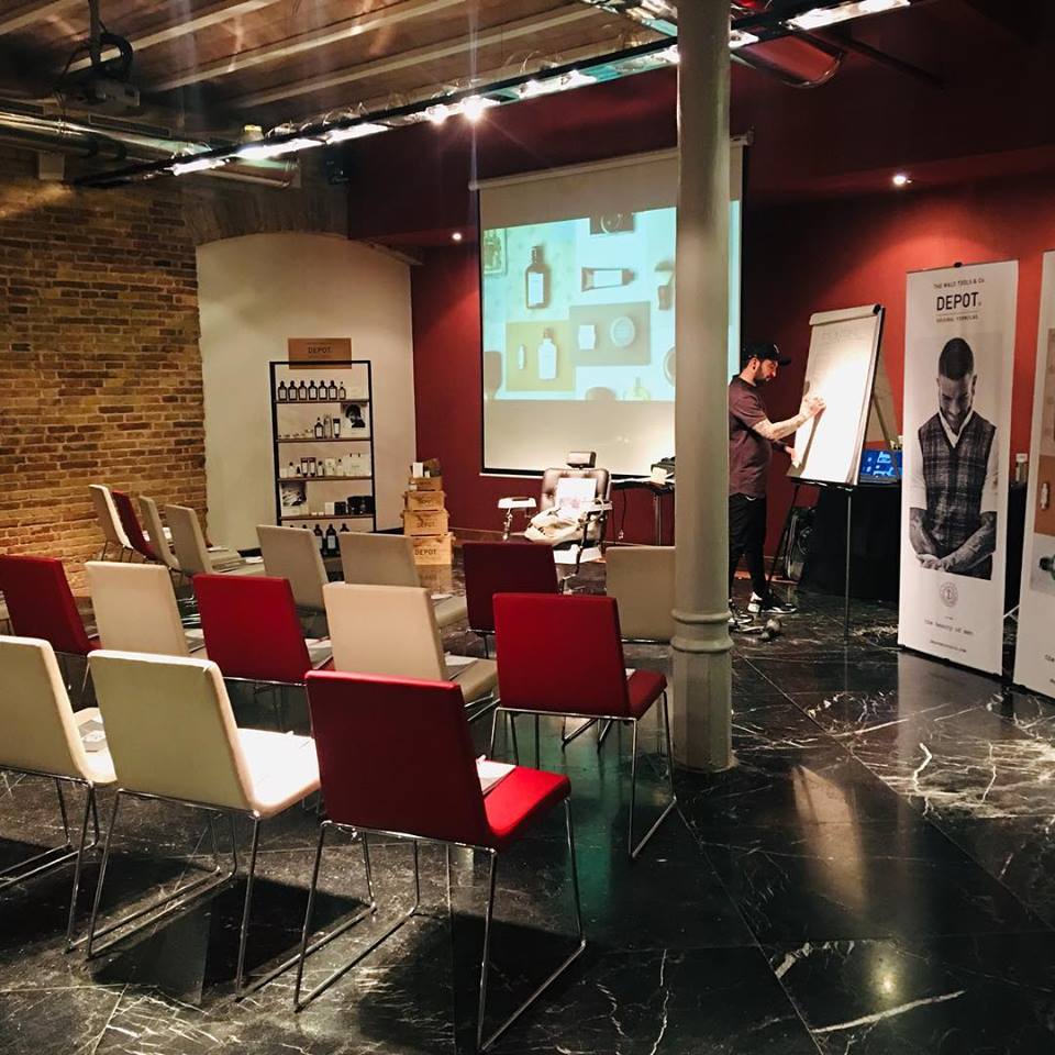 Una sala con sillas rojas y una pantalla de proyección.