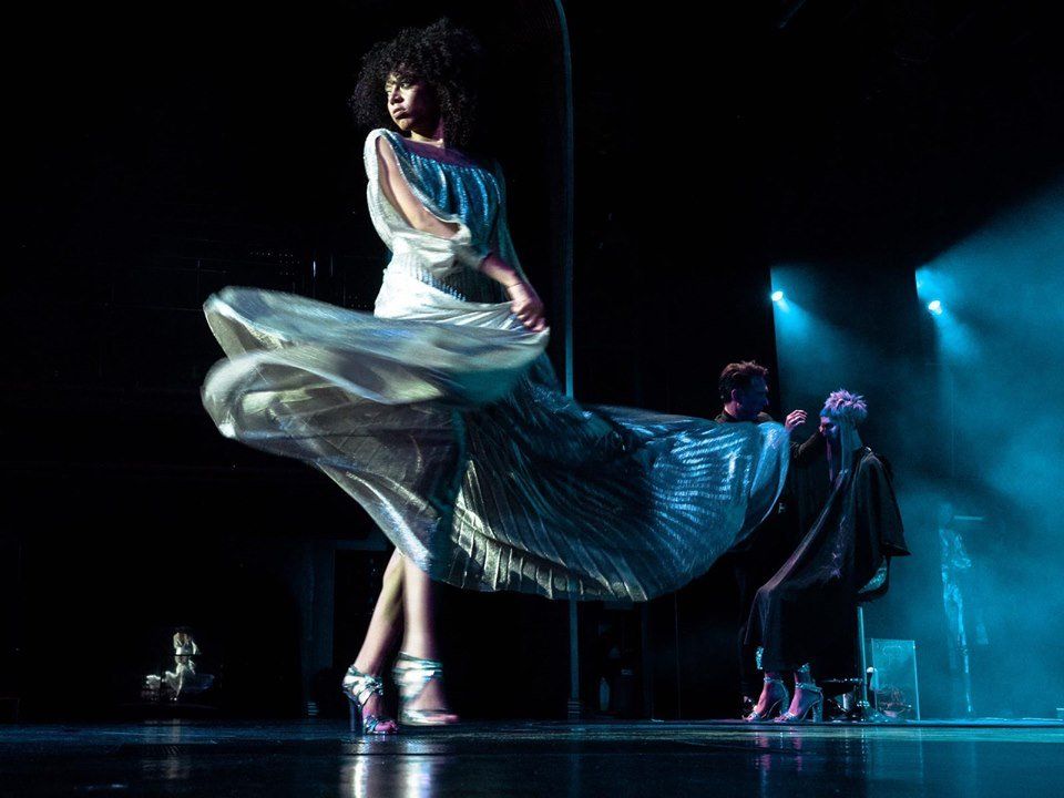 Una mujer con un vestido largo está bailando en un escenario.