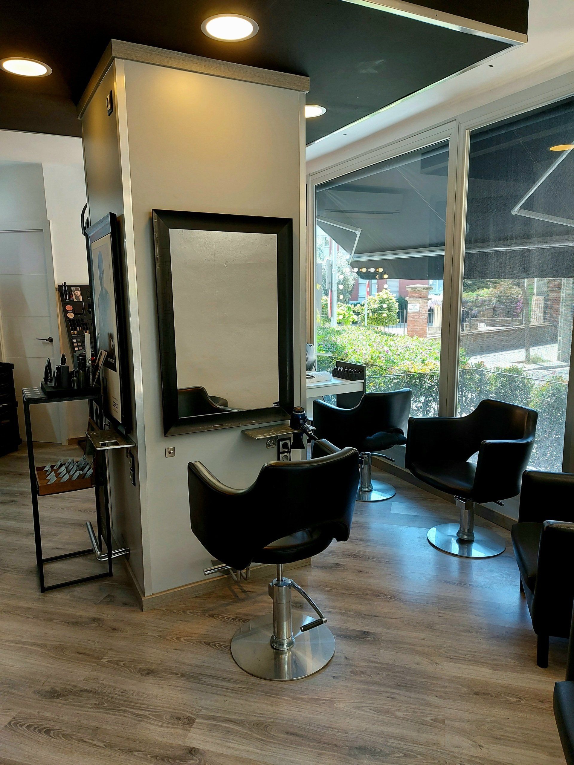 Un salón con sillas y un espejo en la pared.