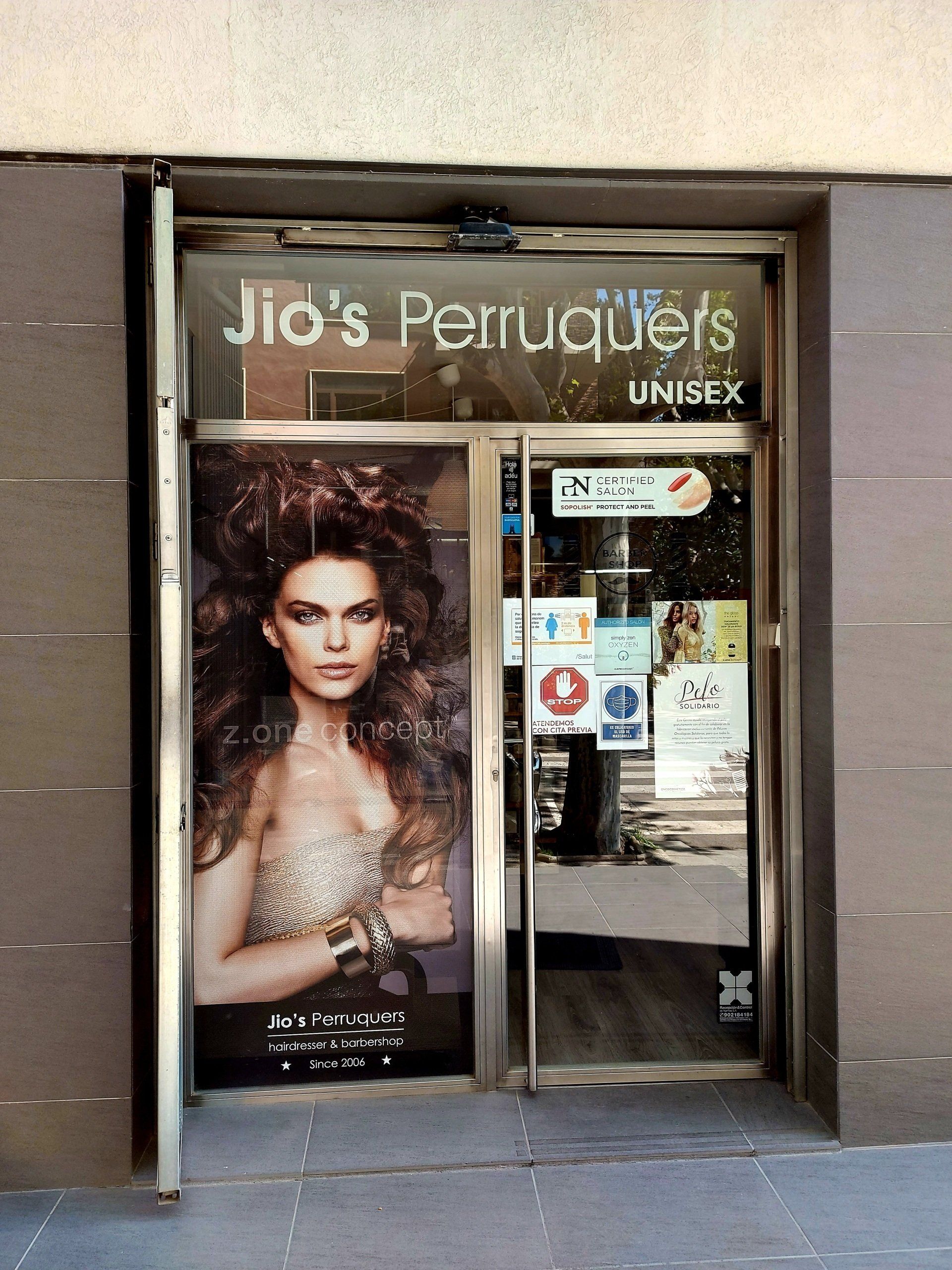 La puerta principal de Jio's Perruquers tiene una foto de una mujer.