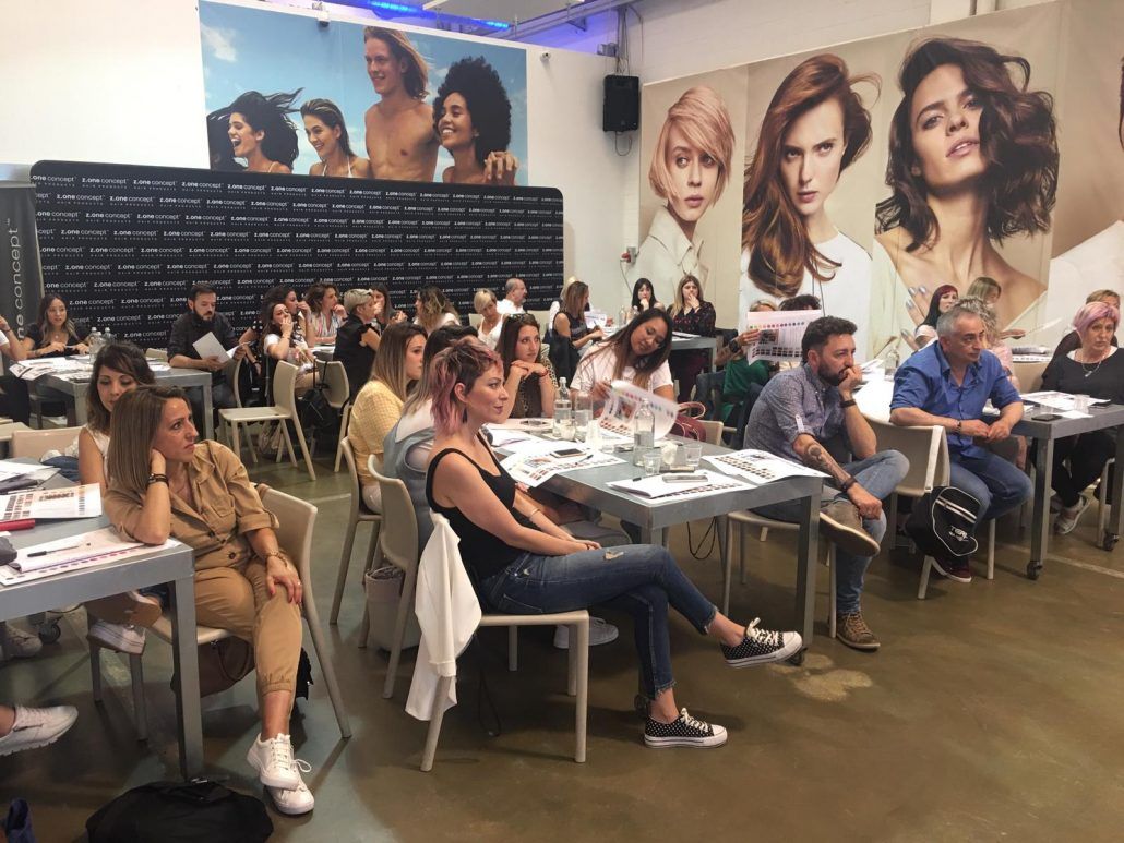 Un grupo de personas están sentadas en mesas en una habitación.