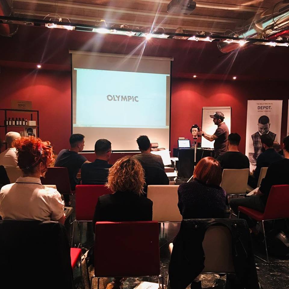 Un grupo de personas está sentado frente a una pantalla de proyección que dice olímpico