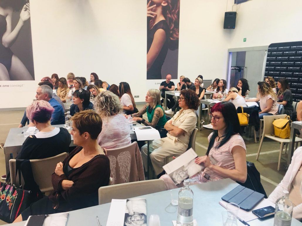 Un grupo de personas están sentadas en mesas en una habitación.