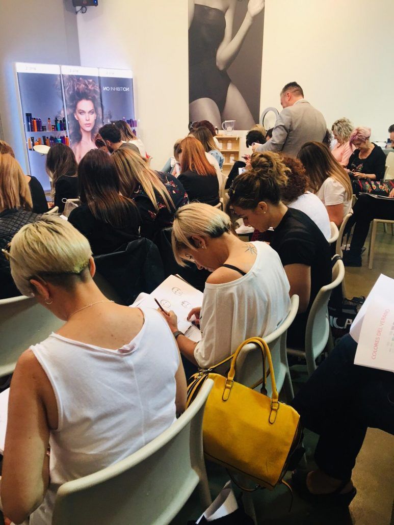 Un grupo de personas están sentadas en sillas mirando papeles.
