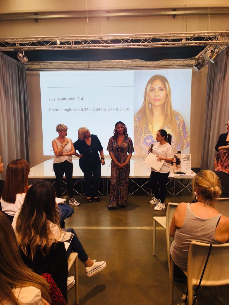 Un grupo de mujeres están sentadas en sillas frente a una pantalla de proyector.