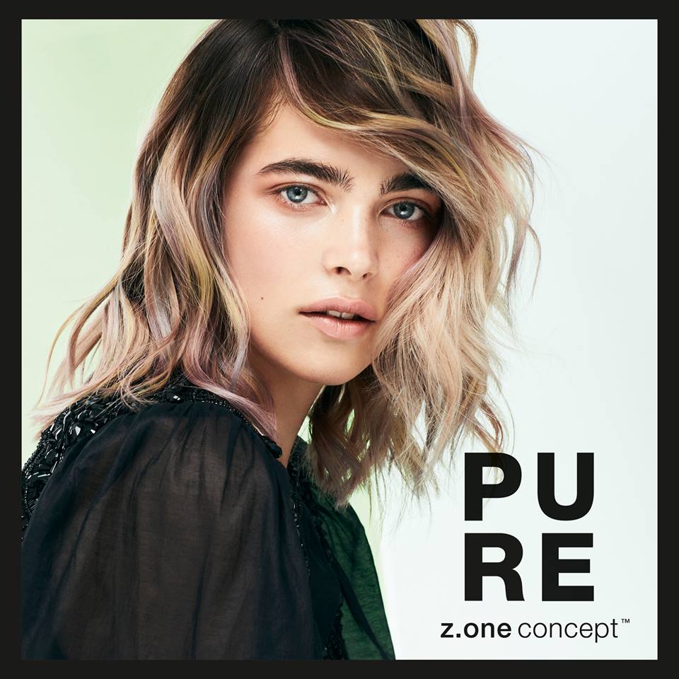 Una mujer de cabello rubio y ojos azules lleva una camisa negra.