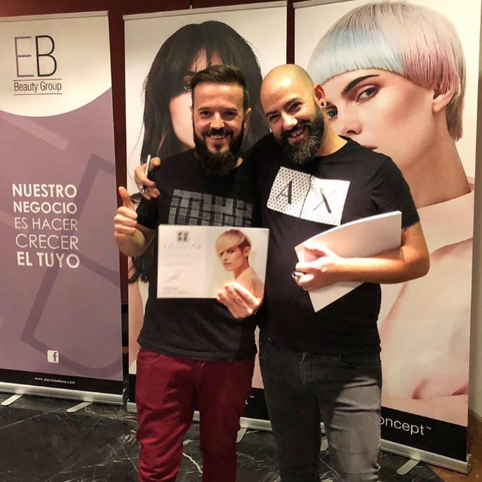 Two men standing next to each other in front of a sign that says nuestro negocio es hacer crecer el tuyo