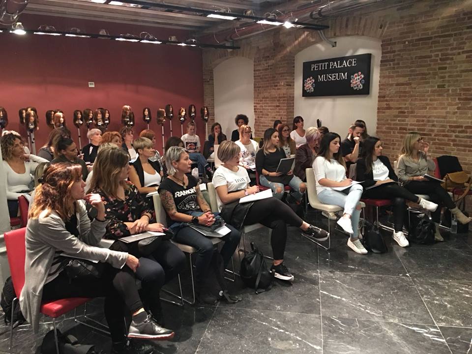 Un grupo de personas están sentadas en sillas en una habitación.