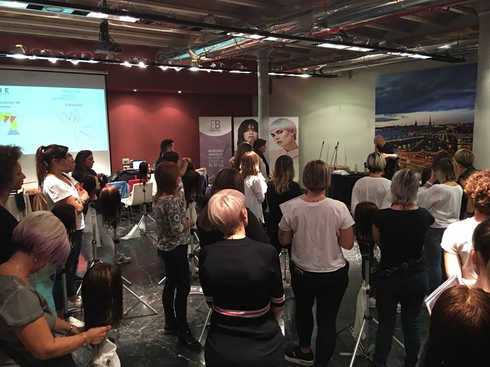 Un grupo de personas está de pie en una habitación viendo una presentación.
