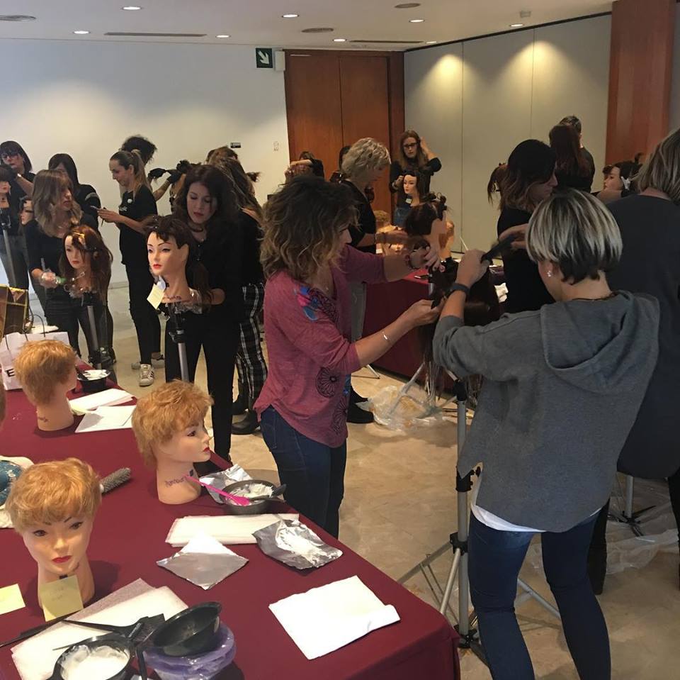 Un grupo de personas están de pie alrededor de una mesa con cabezas de maniquí.