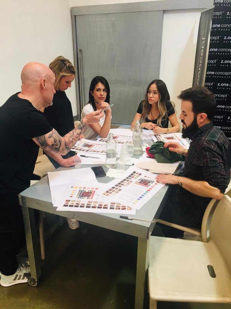 Un grupo de personas está sentado alrededor de una mesa con papeles encima.