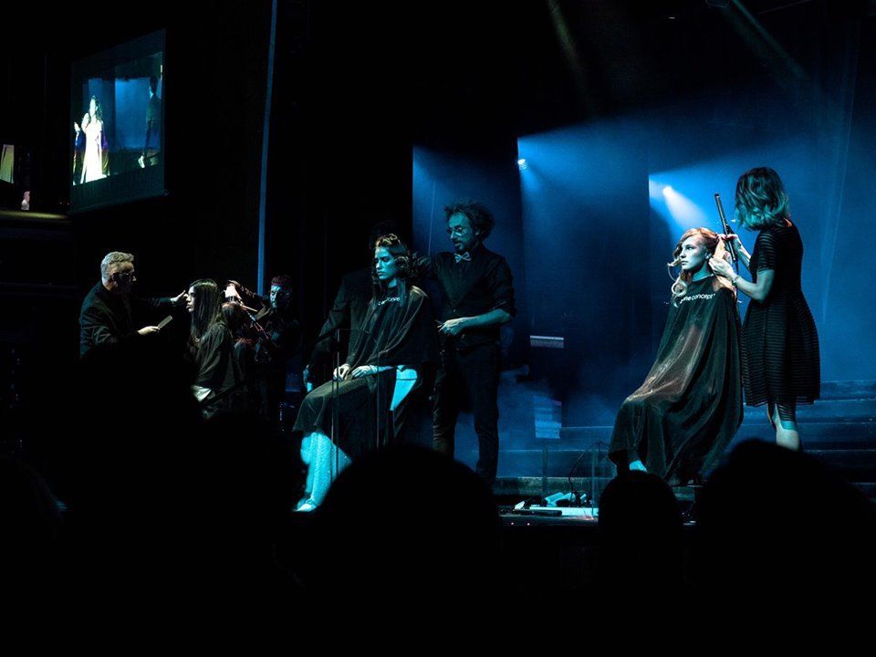 Un grupo de personas se están cortando el pelo en un escenario.