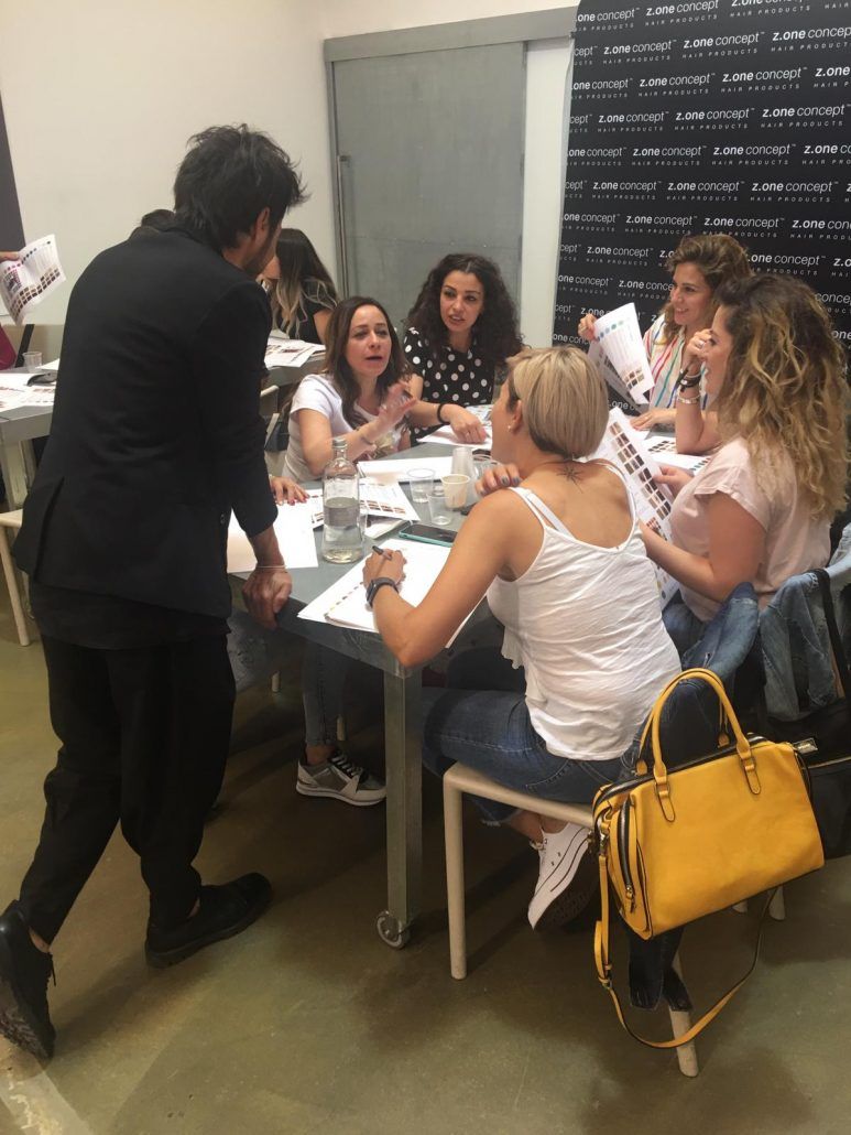 Un grupo de personas están sentadas alrededor de una mesa hablando entre sí.