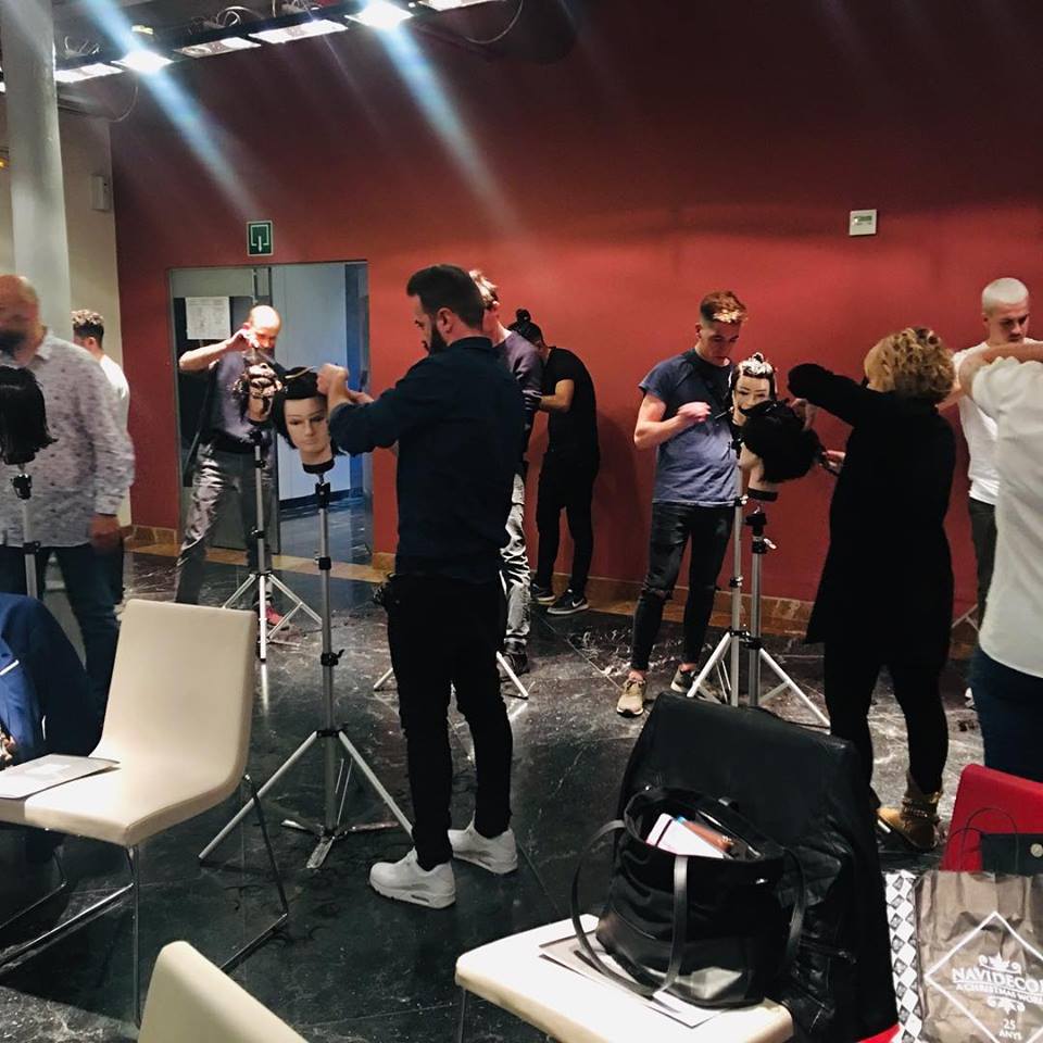 Un grupo de personas están de pie alrededor de maniquíes en una habitación.