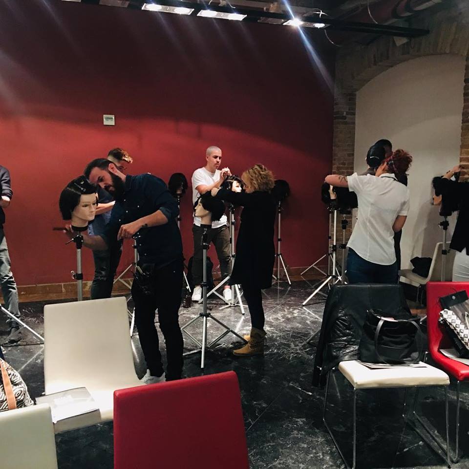 Un grupo de personas están de pie en una habitación con maniquíes.